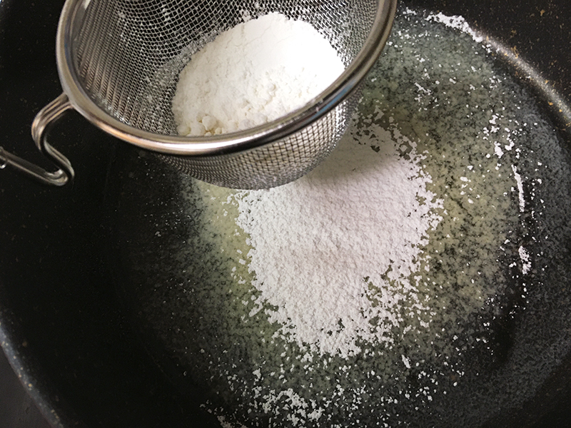 ホワイトソースを作る　とかしたバターに小麦粉をふるい入れる